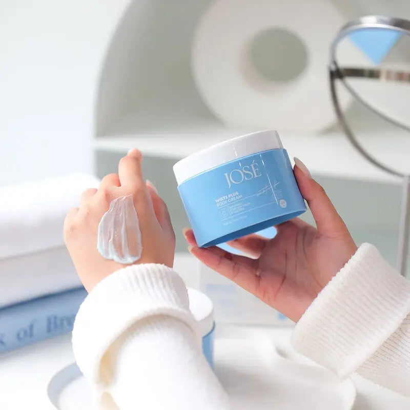 Person applying cream from a blue jar labeled 'JOSE' on their wrist.