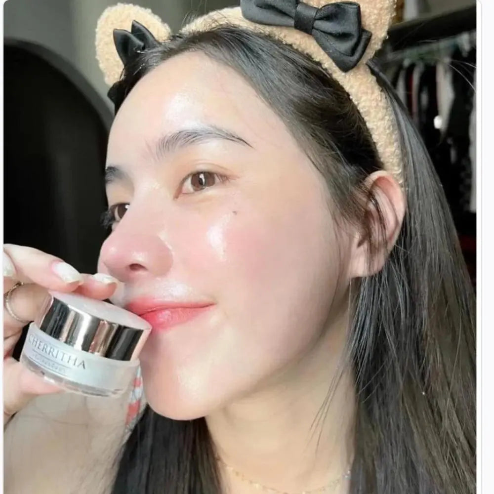 Person applying cream to face with a headband featuring bear ears and a bow.