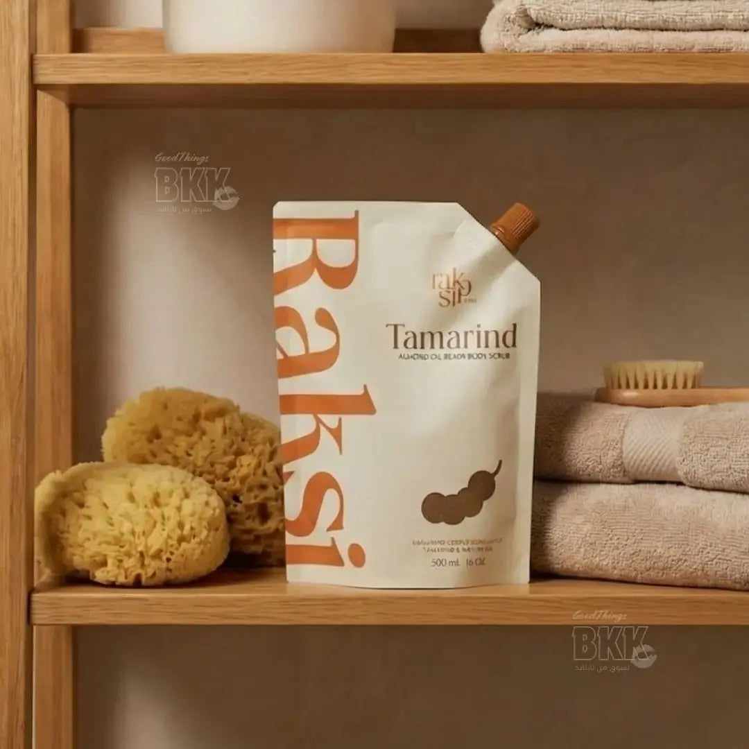 Baks Tamarind body scrub packaging on a wooden shelf with sponges and towels.