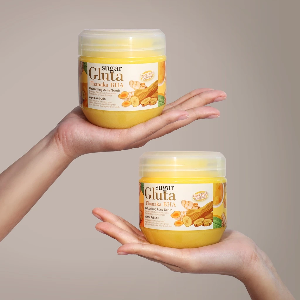 Two hands holding jars of Sugar Gluta product against a neutral background