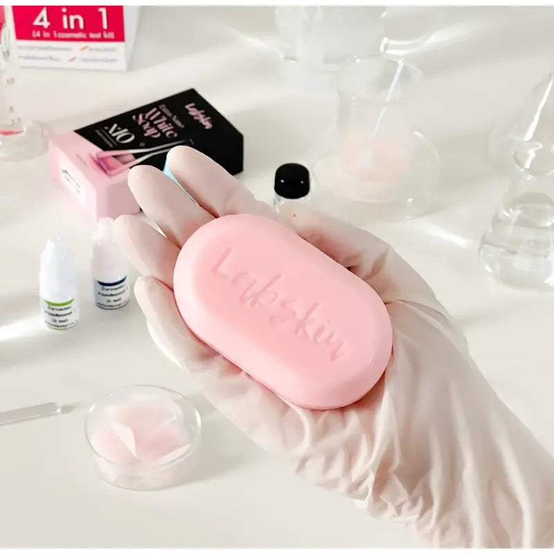 Pink soap bar with 'Lush' branding held by a gloved hand, surrounded by nail care products.
