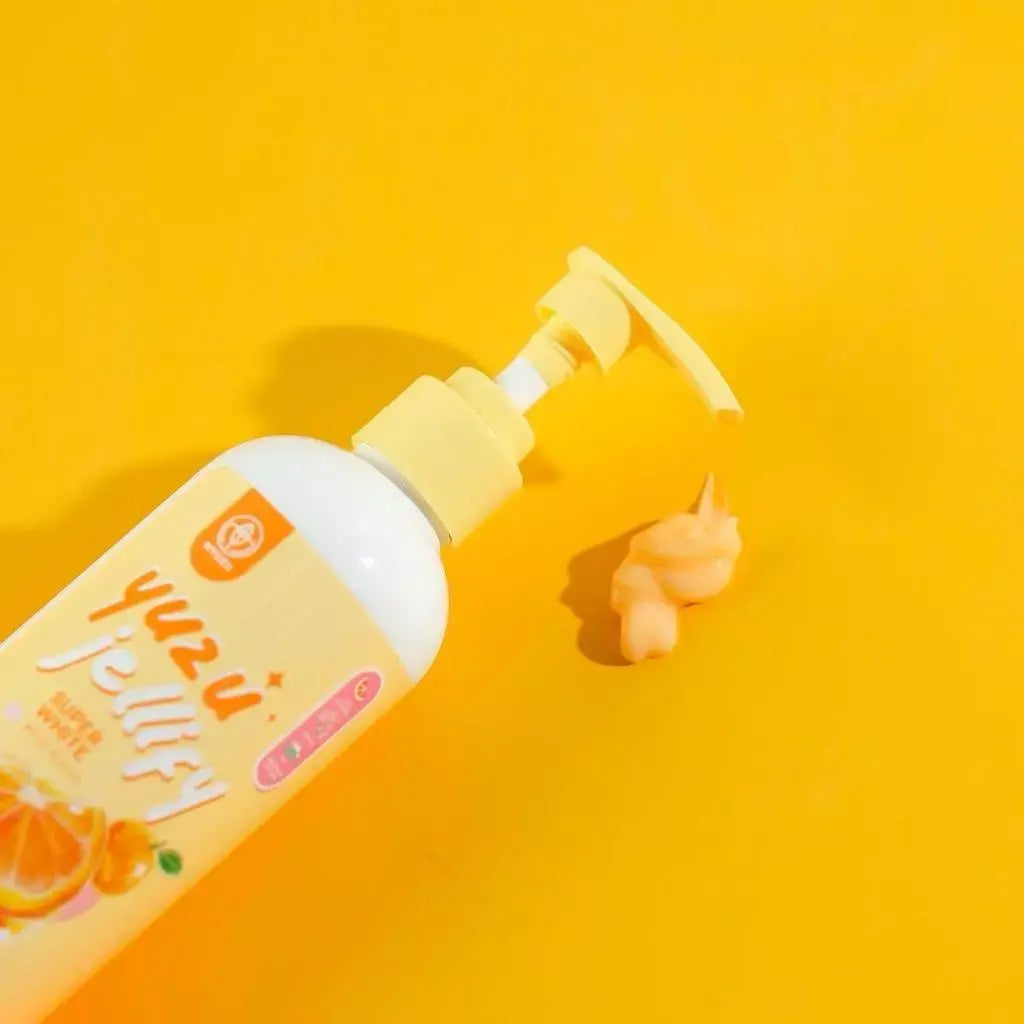 Bottle of 'Yuzu Fruity' product with pump on a yellow background
